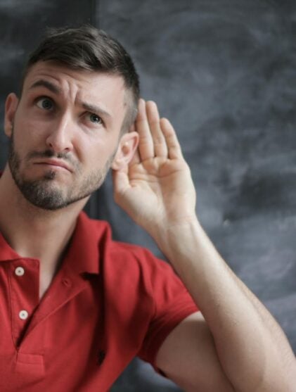 Man in Red Polo Shirt Sitting Near Chalkboard